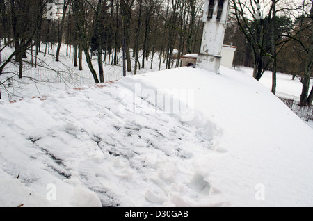 In parte depurata tetto ricoperto da una fitta neve invernale strato. Foto Stock