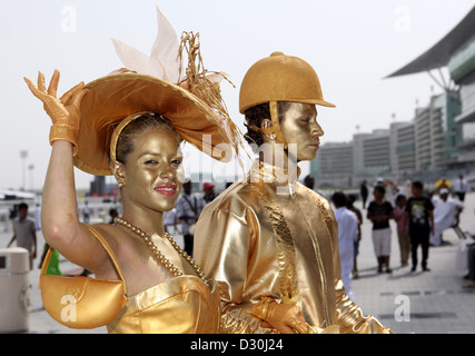 Dubai, Emirati arabi uniti, donne e uomini vestiti in oro a gare Foto Stock