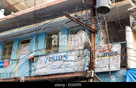 Elettricità pilone, cavi e lampione in un Indiano street di Puttaparthi, Andhra Pradesh, India Foto Stock