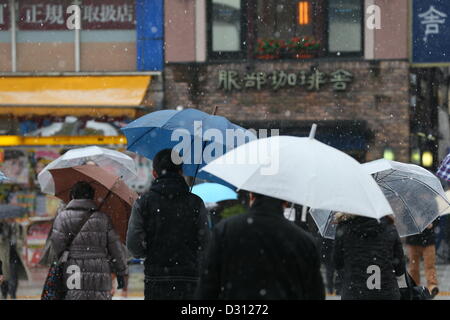 Febbraio 6, 2013, Tokyo, Giappone - i pedoni a piedi nella neve a Tokyo il Mercoledì, 6 febbraio 2013. La neve ha iniziato a cadere nel predawn ore di febbraio 6 nella regione metropolitana. Il Meteorological Agency originariamente previsto di circa dieci centimetri di neve potrebbe cadere su Tokyo centrale da mezzogiorno del 6 febbraio ma temperature crescenti aveva girato molto della caduta di neve a pioggia e grandine durante la mattina e la poca neve ha raccolto sul terreno. (Foto di YUTAKA/AFLO) Foto Stock