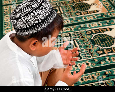 Ragazzo musulmano in preghiera nella moschea Foto Stock