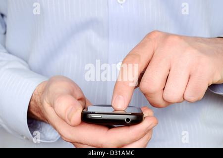 Uomo che utilizza uno Smartphone, vicino. Foto Stock