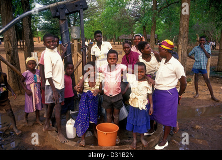 Popolo dello Zimbabwe, delle donne e dei bambini e il pompaggio di acqua dal pozzo, acqua bene, bene acqua, villaggio di Mahenye, Manicaland Province, Zimbabwe, Africa Foto Stock