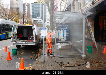 Società privata di pulizia per la pulizia del team un bus shelter con il tubo flessibile di alimentazione Vancouver BC Canada Foto Stock