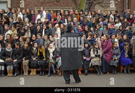 Gli studenti ebrei asiatici israeliani ascoltano un discorso prima di presentare una foto di gruppo alla sede centrale di Lubavitch a Brooklyn, New York Foto Stock