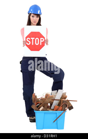 Ragazza con casco di sicurezza tenendo premuto stop Foto Stock