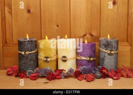 Cinque masterizzazione di Feng Shui candele e pot-pourri contro un pannello di legno Foto Stock