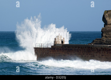 Un mare tempestoso colpisce la parete del porto a Portreath in Cornwall, Regno Unito Foto Stock