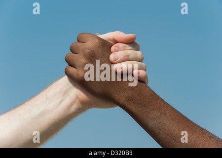 Indian e in inglese le mani. Occidentali e Orientali di agitare a mano contro un cielo blu. l'india. Un concetto di umanità. Foto Stock