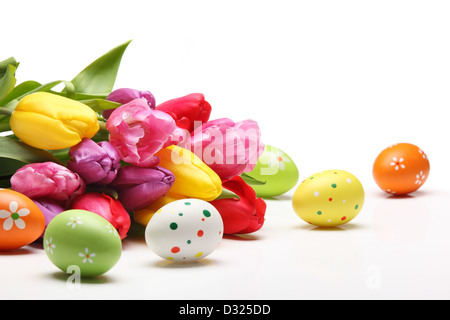 Le uova di Pasqua con i tulipani su sfondo bianco. Foto Stock