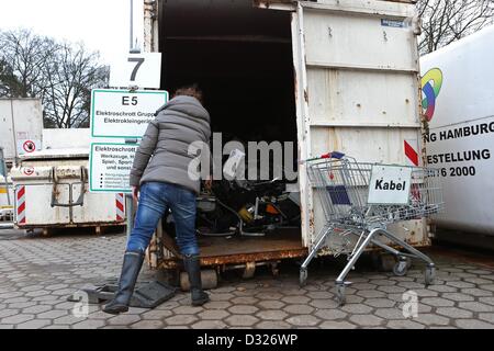 Una donna scarta gli elettrodomestici e il loro consolidamento in un unico contenitore per rottami di elettronica presso il riciclaggio Bahrenfeld park ad Amburgo, Germania, il 4 febbraio 2013. Foto: Christian Charisius Foto Stock