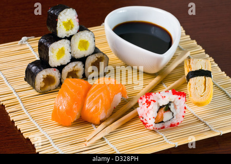 Sushi in fila sul tappetino di bambù Foto Stock