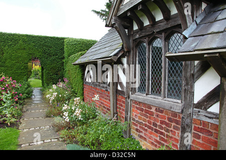 Il mezzo in legno edificio conosciuto come il tè Cottage in rosa ad arbusto Giardino a Arley Hall gardens Cheshire England Regno Unito Foto Stock