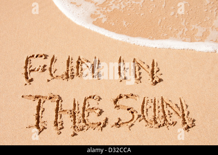 Divertimento al sole scritto di sabbia su una spiaggia Foto Stock