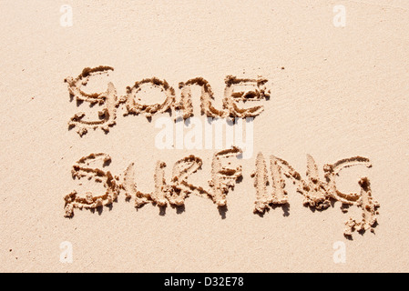 Gone surfing scritto di sabbia su una spiaggia Foto Stock
