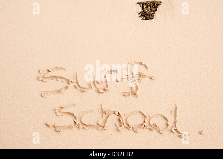 Scuola di surf scritto nella sabbia sulla spiaggia Foto Stock