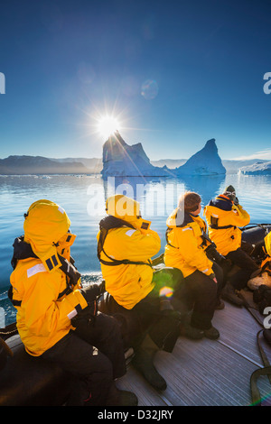 Turistico a Zodiacs esplorando e fotografando iceberg, Scoresbysund, Groenlandia Foto Stock