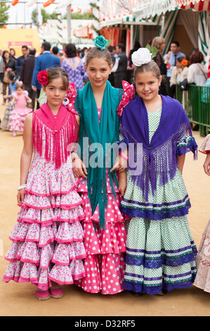 Le giovani ragazze vestite di colorati abiti di flamenco durante la Feria de Sevilla, Spagna Foto Stock
