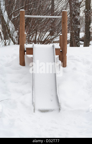 Svuotare i bambini nel suo scorrimento coperto di neve. Foto Stock