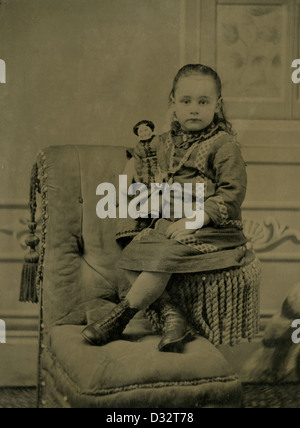 Circa 1870 tintype fotografia, una bambina con la sua bambola vittoriana. Foto Stock