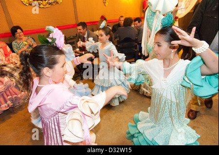Le giovani ragazze in colorati abiti di flamenco dancing in una caseta a Feria de Sevilla, Spagna Foto Stock