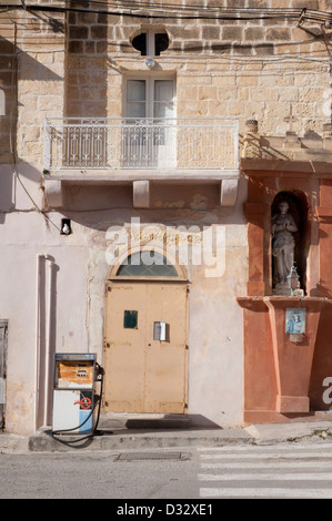 Gozo, scene di strada pacifica, nessun popolo, senza traffico, muri in pietra, lastra di pietra , vecchio in disuso della pompa benzina. balcone, statua Foto Stock