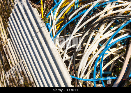 In dumping illegale di amianto di pacciamatura in plastica con guaina di filo a sinistra dal metallo theives chi ha rubato il cablaggio Foto Stock