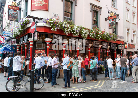 Persone di bere al di fuori del pullman e cavalli pub di Soho, London, England, Regno Unito Foto Stock