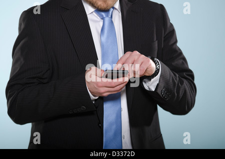 Imprenditore utilizza lo smartphone. Sezione centrale di casualmente adatto uomo con un touch screen telefono cellulare con il suo dito. Foto Stock