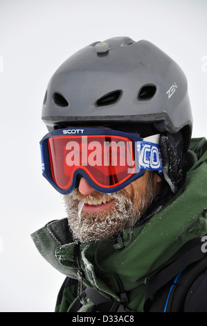 Sciatore con un freddo gelido di barba e congelati di gocciolamento del naso. Foto Stock