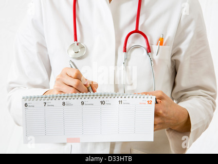 Immagine simbolica della medicina. Medico è scrivere gli appuntamenti in una calandra. Foto Stock