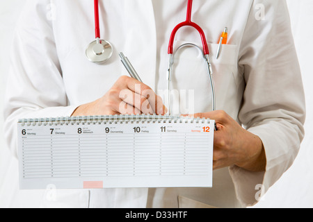 Immagine simbolica della medicina. Medico è scrivere gli appuntamenti in una calandra. Foto Stock