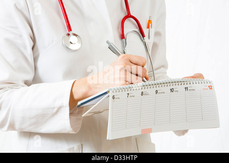 Immagine simbolica della medicina. Medico è scrivere gli appuntamenti in una calandra. Foto Stock