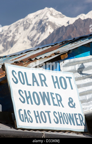 Una casa da tè nel foothills dell'Himalaya, Nepal, la pubblicità di una doccia calda alimentato da energia solare termica pannelli. Foto Stock