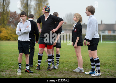 Una ragazza entra a far parte di un gruppo di ragazzi che per una partita di calcio a Pâté Grammar School di Cheltenham, Gloucestershire REGNO UNITO Foto Stock