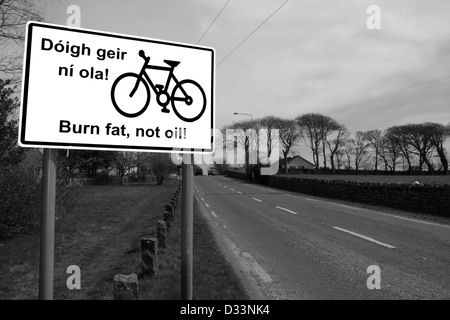 Bruciare i grassi non olio irish cartello stradale su una tranquilla strada entrando in una città in Irlanda in bianco e nero Foto Stock