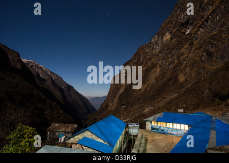 Il cielo di notte su un picco nel Santuario di Annapurna Himalaya,, Nepal, con una casa da tè in froeground. Foto Stock