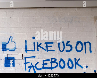 Come noi su facebook chiamata all azione dipinta su un muro di mattoni. Foto Stock