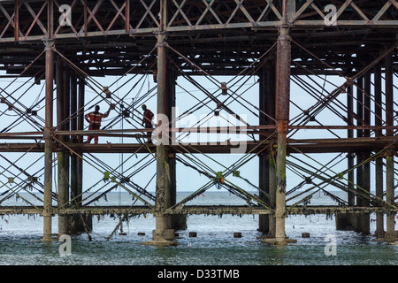 Operai che lavorano sotto Cromer Pier durante i lavori di ristrutturazione in agosto 2012 Norfolk East Anglia England Foto Stock