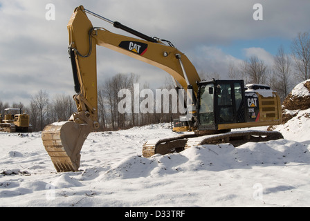 Escavatore Cat parcheggiata sul sito in costruzione. Foto Stock