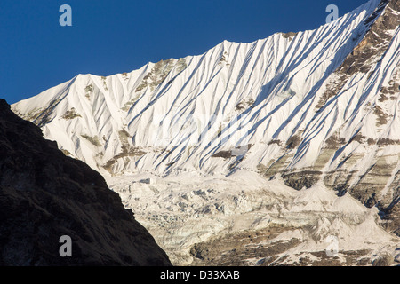 Rapidamente un ghiacciaio in ritirata sul lato del 6428 misuratore di picco Gandharwa Chuli nel santuario di Annapurna, Foto Stock