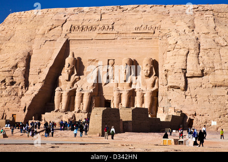 I turisti al famoso sito del Grande Tempio di Abu Simbel Egitto scompaiono di fronte alle enormi statue di Ramesse II Foto Stock