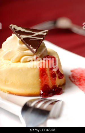 Una ricca vaniglia mousse con panna montata e salsa di lamponi Foto Stock