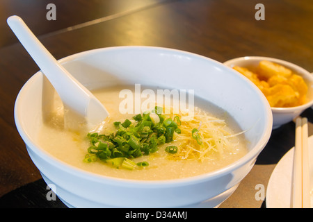 Ciotola di riso congee cinese porridge con lo scalogno e lo zenzero Closeup Foto Stock