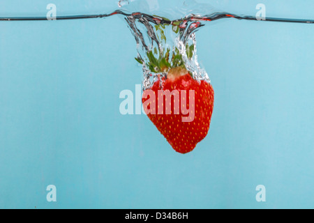 Fragola cadere in acqua con fotografia stop motion per catturare l'azione Foto Stock