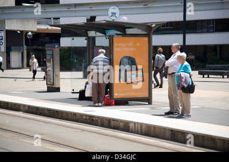 I passeggeri in attesa di un tram per arrivare in Hay Street,Chinatown di Sydney Foto Stock