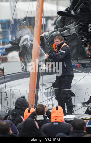 Portsmouth, Regno Unito. 9 febbraio 2013. Alex Thomson a bordo di Hugo Boss festeggia il suo arrivo con champagne a Haslar Marina, Gosport il 9 febbraio dopo essere arrivato terzo nel Vendee Globe gara in 80 giorni. Credito: Mike francese / Alamy Live News Foto Stock