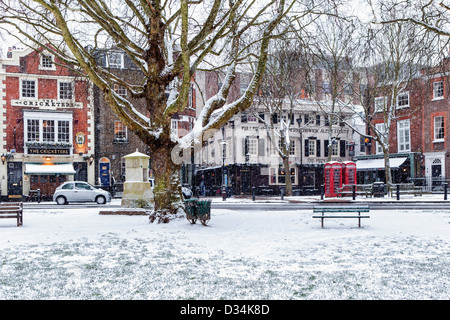 ' Il Cricketers' e 'Il Princes testa', due tipici pub inglesi sulla coperta di neve Richmond Green in inverno, Richmond Upon Thames, Surrey Foto Stock