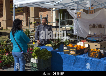 Cliente con stallholder in piedi accanto a frutta e verdure fresche di mercato moneta di stallo Andalusia Spagna Foto Stock