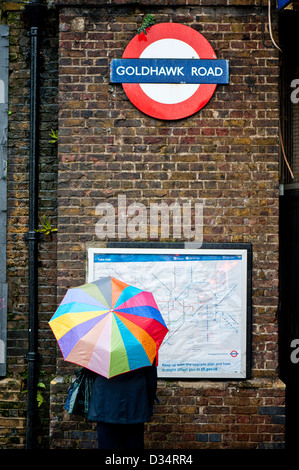 Donna con ombrello da Galdhawk Road tube station, London, Regno Unito Foto Stock